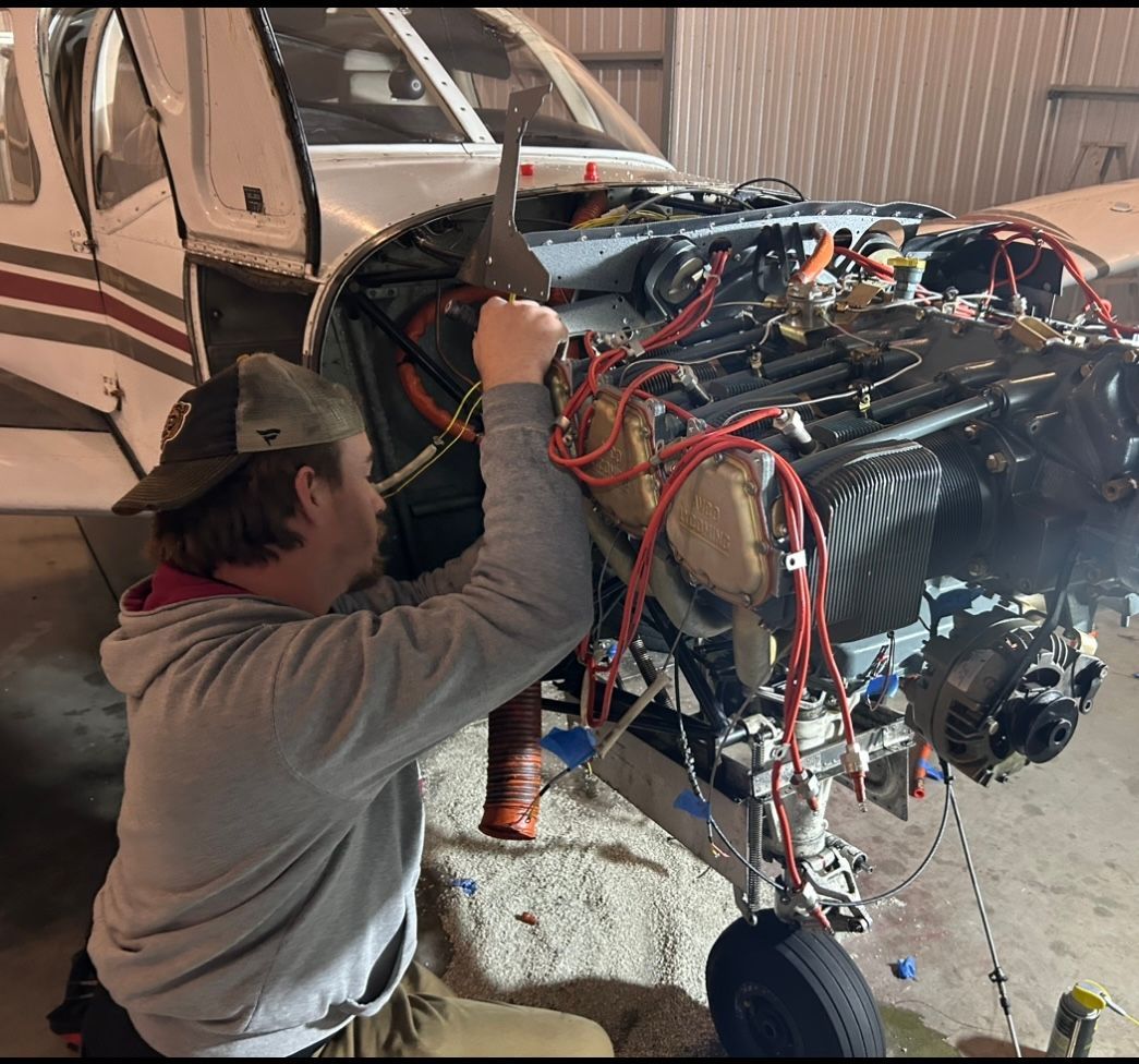 A man is working on the engine of an airplane