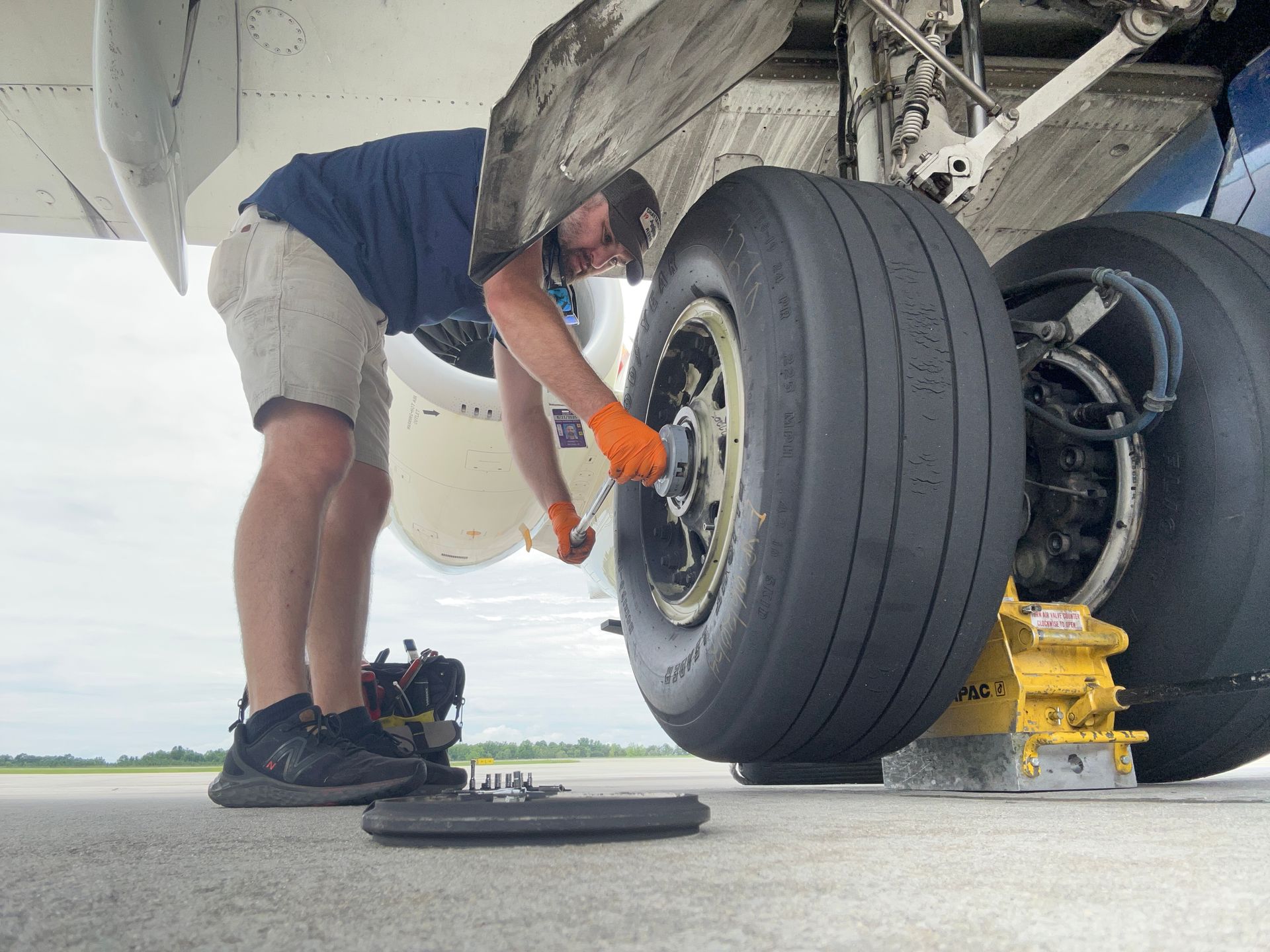 A man is working on the tires of an airplane