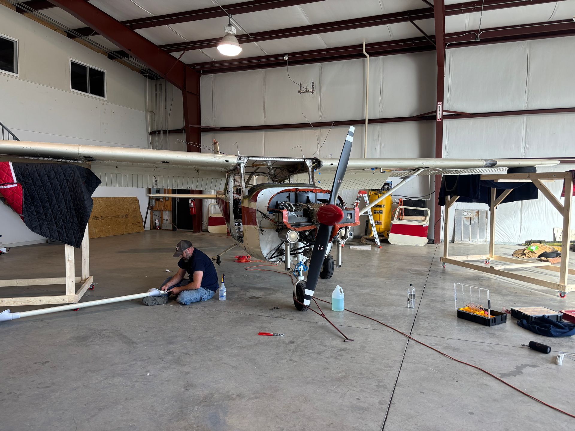 Two men are working on an airplane in a hangar