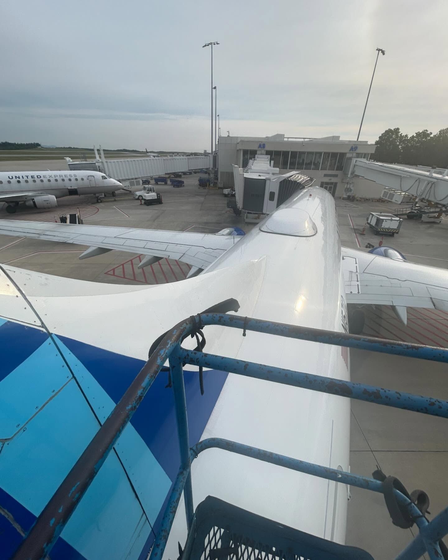 A blue and white airplane is parked at an airport