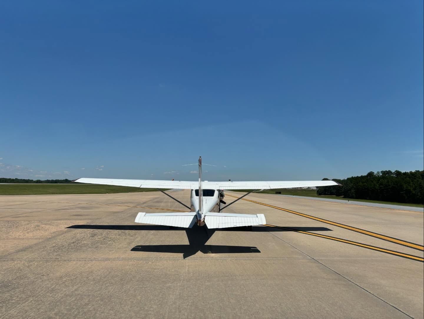 A small white plane is parked on a runway.