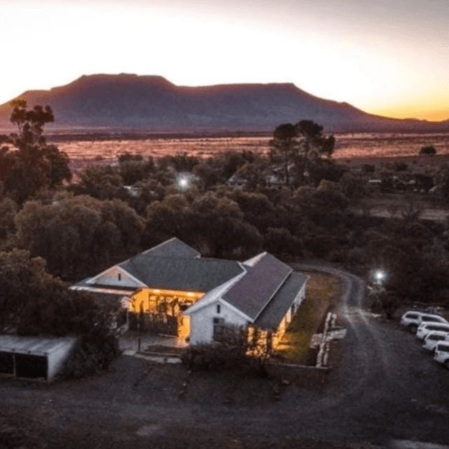 An aerial view of a house with a mountain in the background