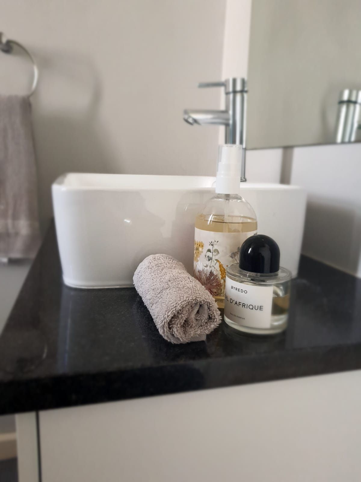 A bathroom sink with a towel and a bottle of soap on the counter.