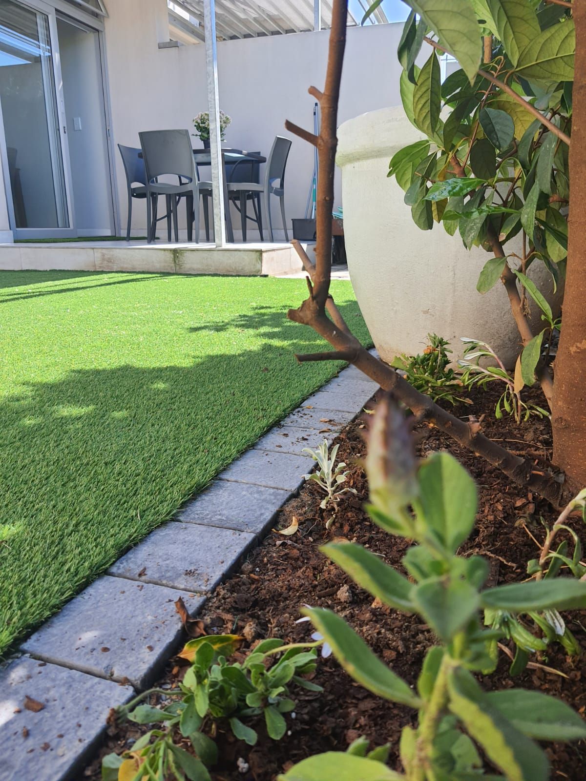 A lawn with a table and chairs in the background