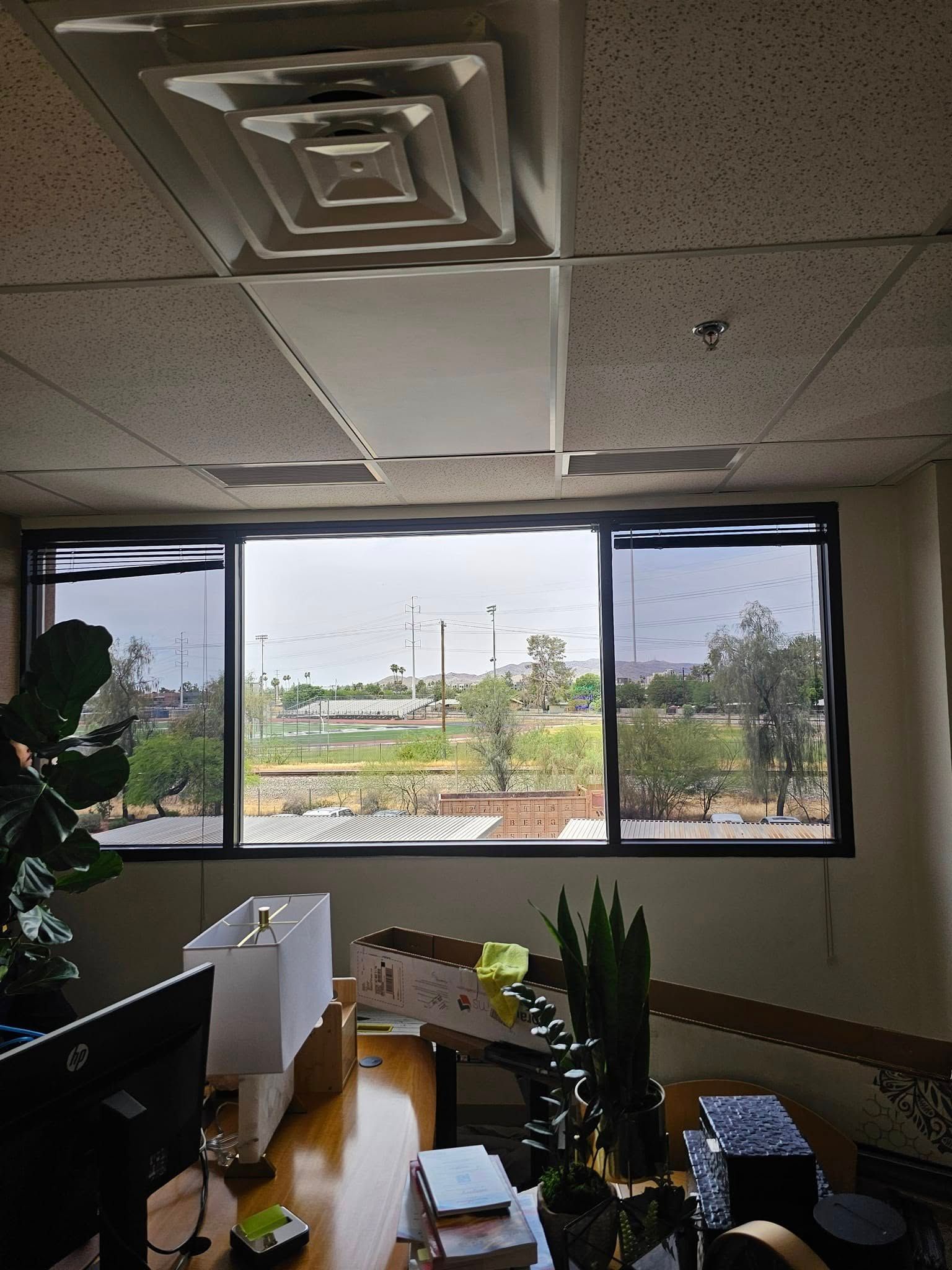 A room with a large window and a ceiling fan