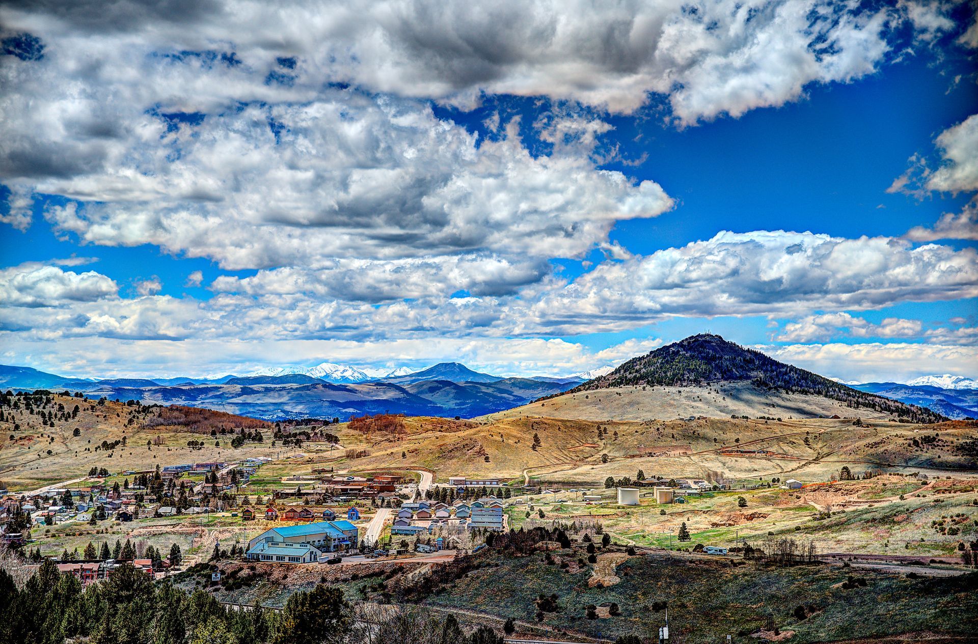 A view of a valley with mountains in the background and clouds in the sky.