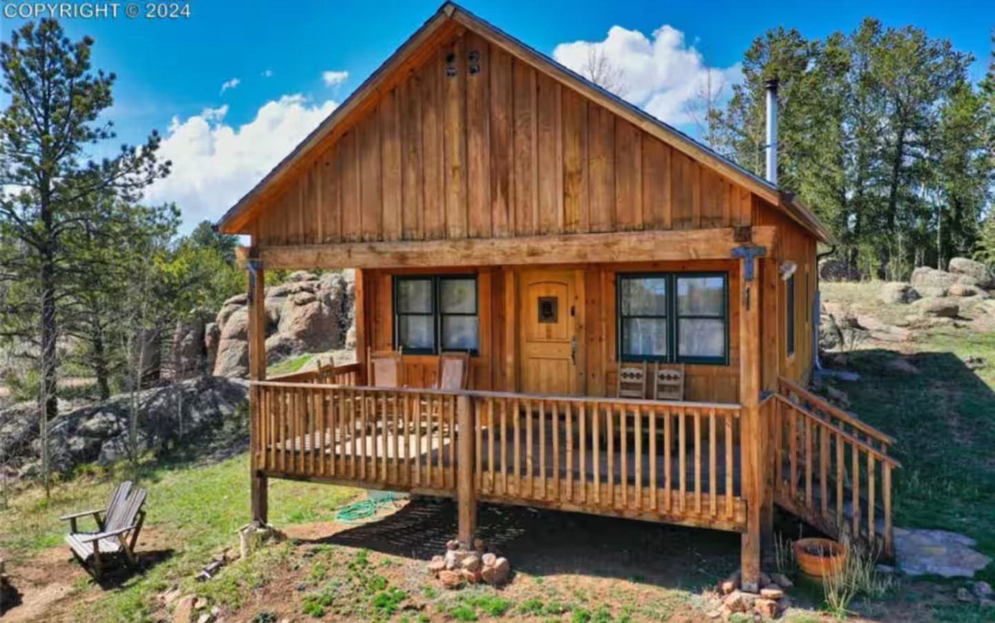 A small wooden cabin with a porch and stairs