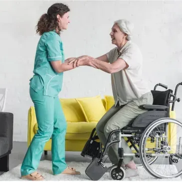 A nurse is helping an elderly woman in a wheelchair.