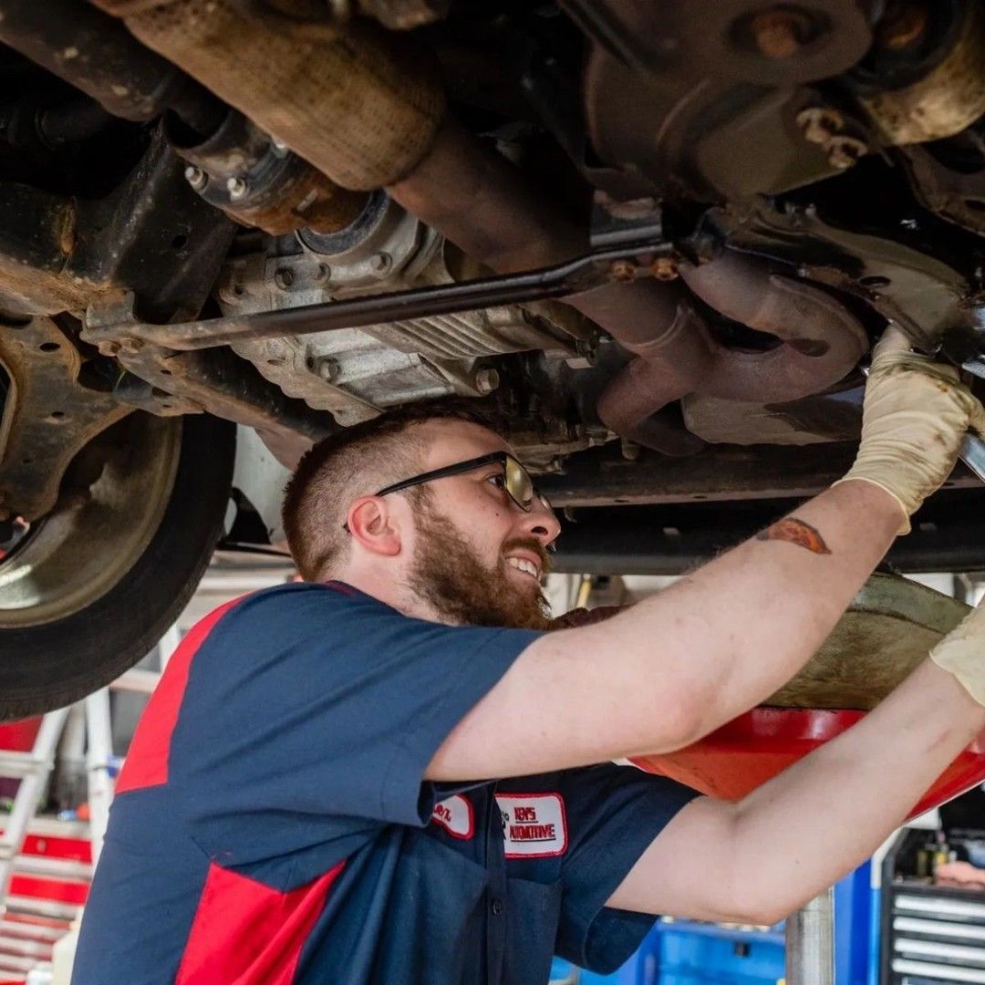 A Man Wearing Glasses Working Under A Car — Wilbraham, MA — Ken’s Automotive