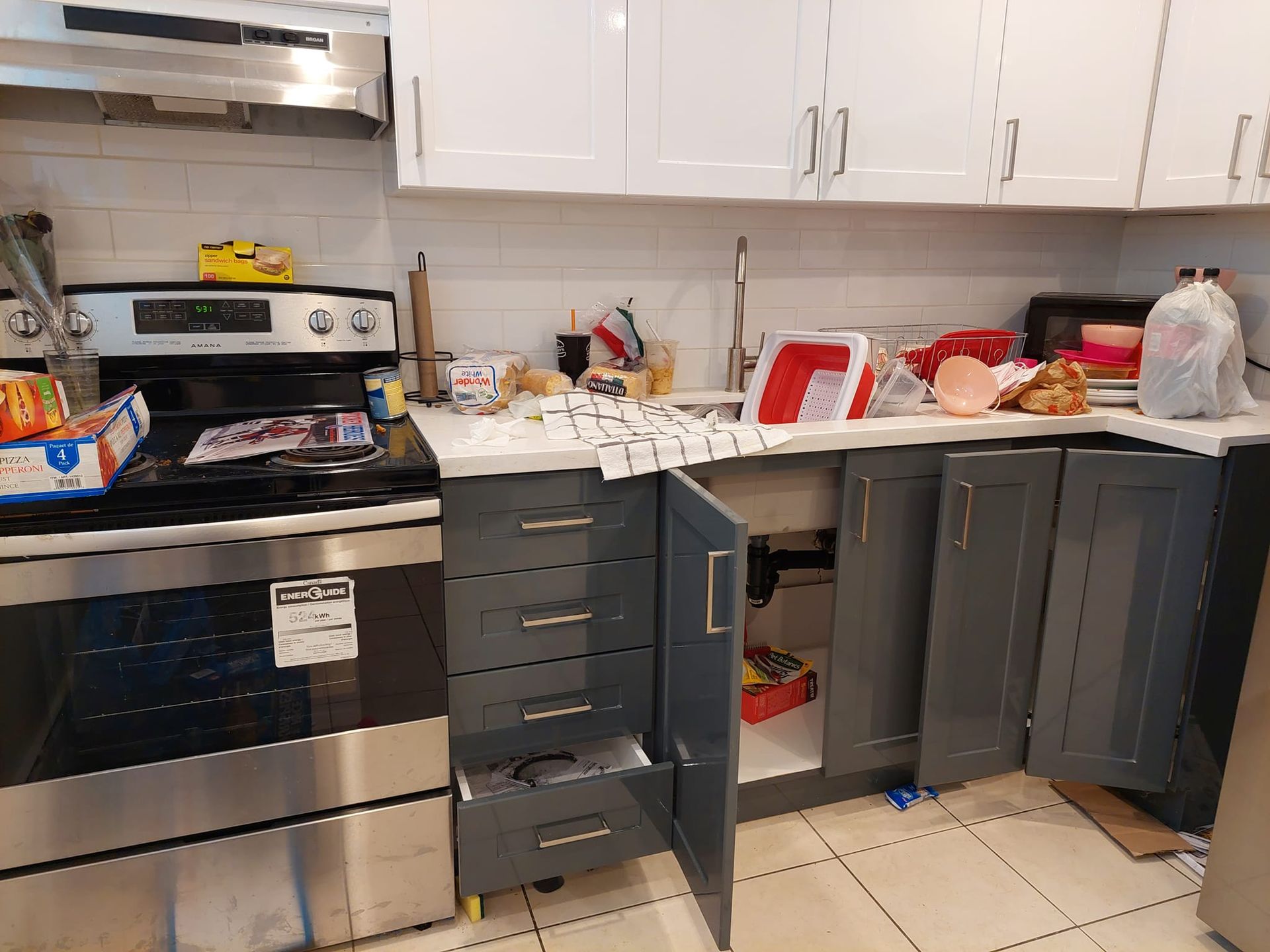 A kitchen with stainless steel appliances and gray cabinets.