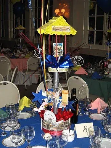 A table set for a party with a carousel centerpiece on it.