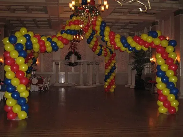 A room decorated with red , yellow and blue balloons