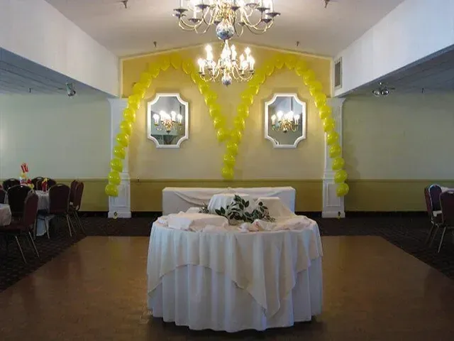 There is a table with a white table cloth in the middle of the room.