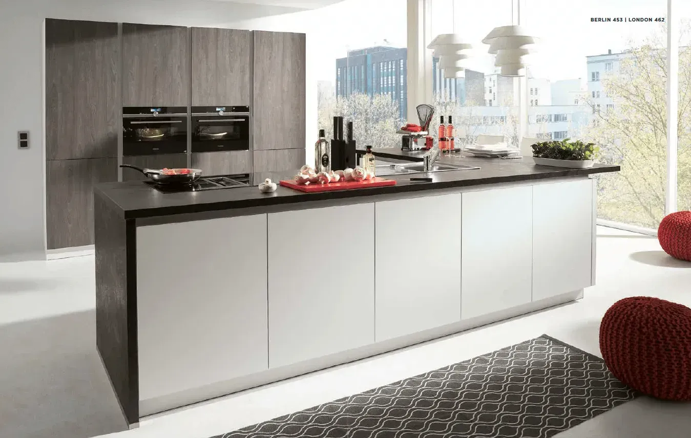 Modern kitchen with large island, stainless steel appliances, and large windows.