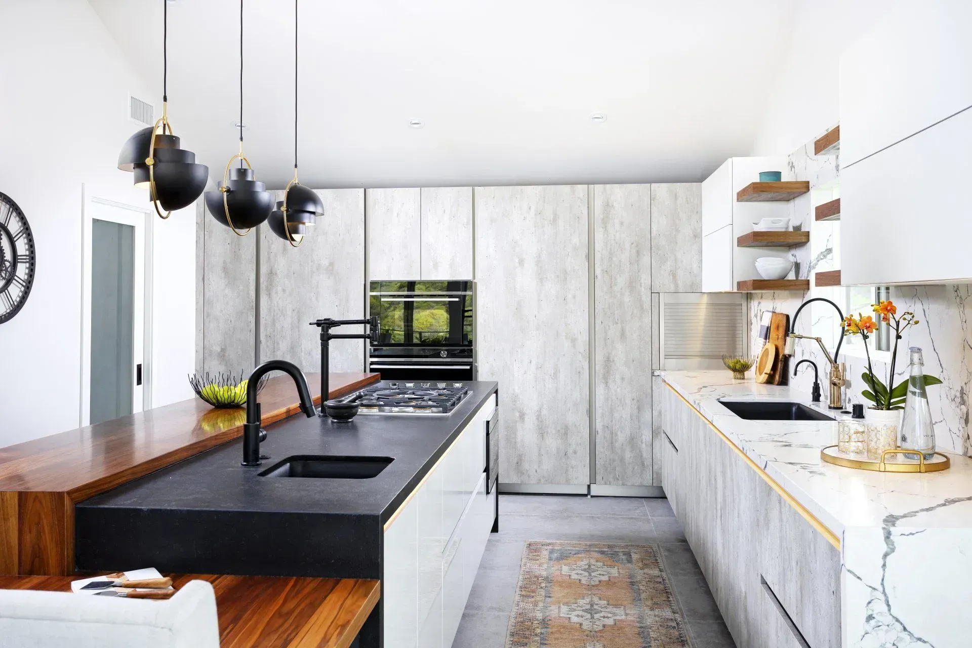 Modern kitchen with island, dark accents, light-colored cabinetry, and warm wooden accents.