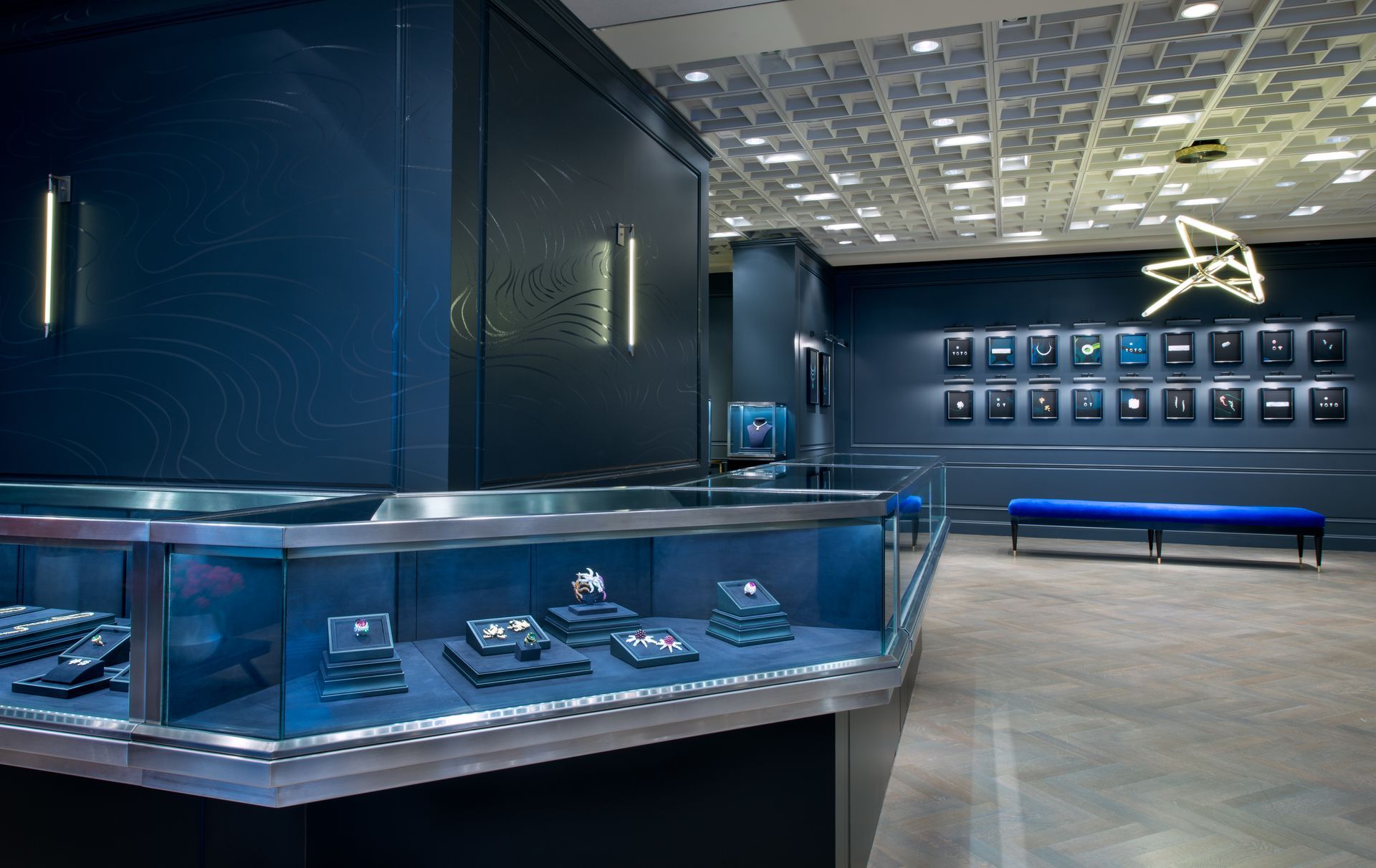 Blue-lit luxury watch boutique with glass display cases and wall-mounted timepieces