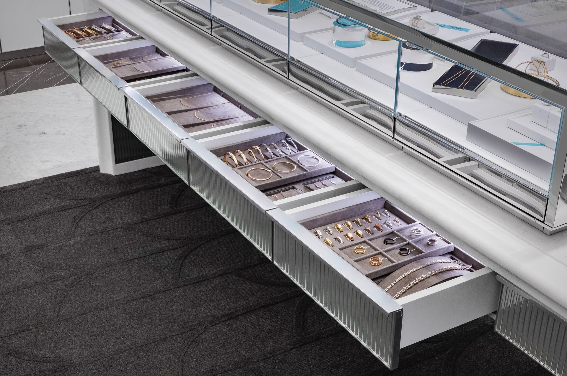 Open refrigerated display case with trays of packaged food in a grocery store
