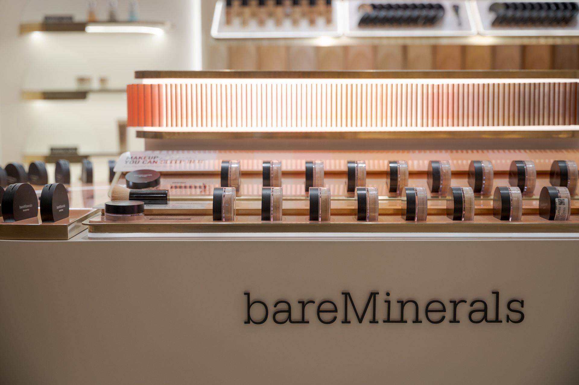 BareMinerals makeup display with cosmetics and brushes on a store counter