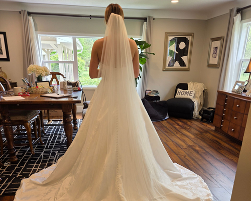 Bride in a wedding gown with a long train and veil at Bridal Fitting Appointment with Sonya Garcia