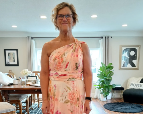 Woman wearing a long pink dress at fitting appointment with Sonya Garcia