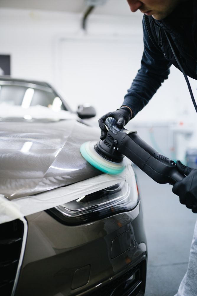 A Man is Polishing the Front of a Car With a Machine — Greg Hennessey Smash Repairs In Woolgoolga, NSW