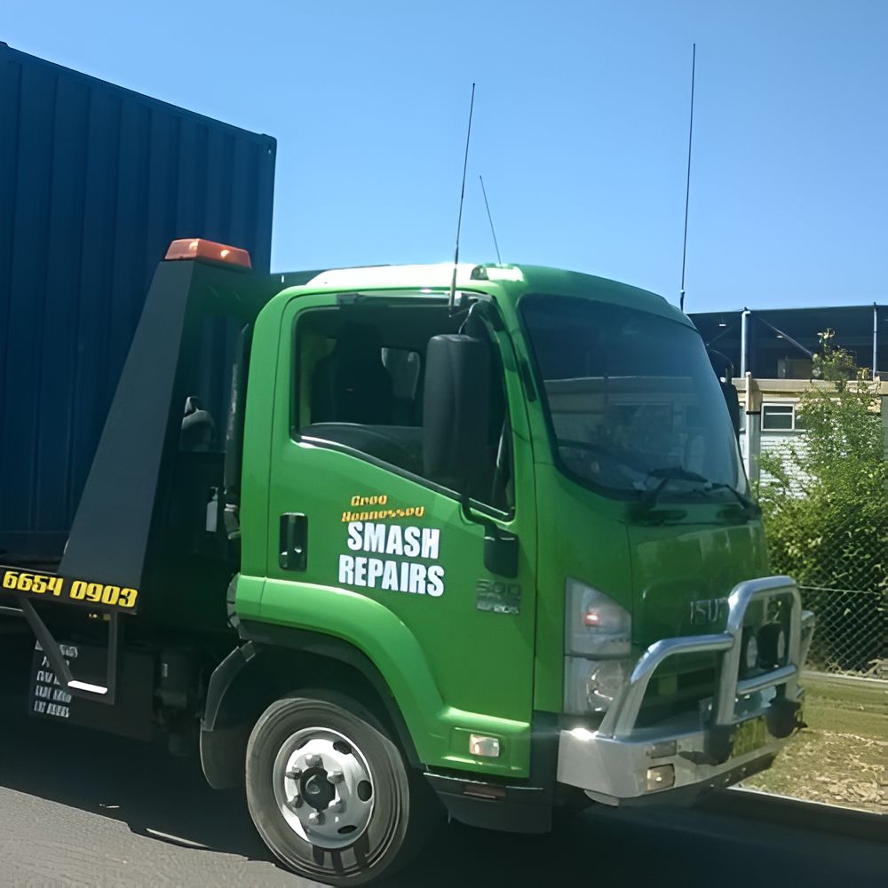 A Green Smash Repairs Truck is Parked on the Side of the Road — Greg Hennessey Smash Repairs In Woolgoolga, NSW