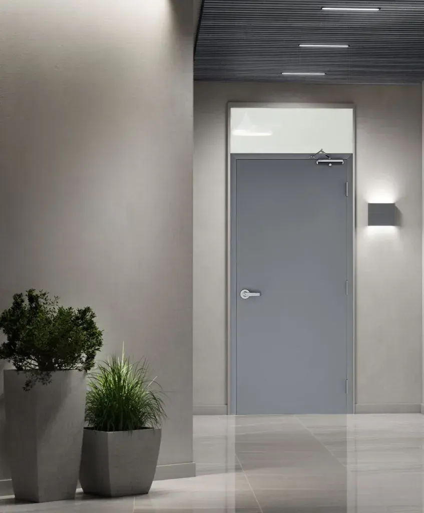 Modern house entrance with dark front door, wood and stone exterior, and landscaped garden.