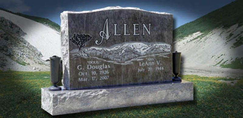 Gravestone for the Allen family set in a grassy landscape with mountains in the background.