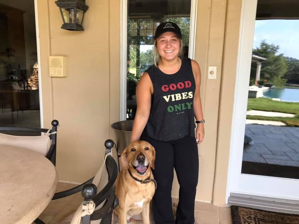 A Woman Standing Next To A Dog