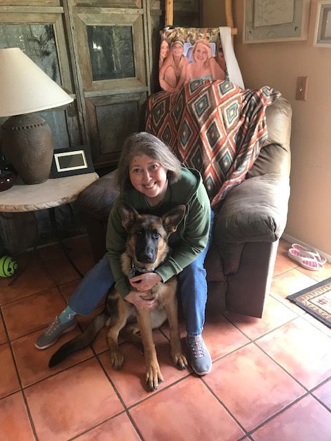 A woman is sitting in a chair with a dog on her lap