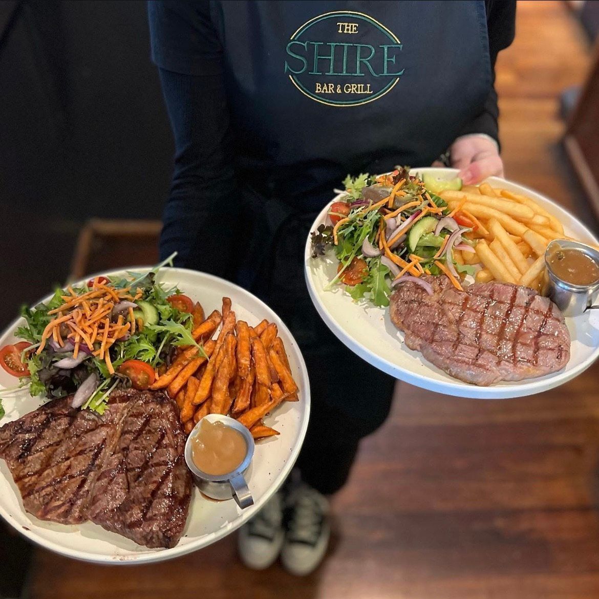 Grilled steaks served with fries, salad, and gravy.— The Shire Bar & Grill In Dubbo, NSW