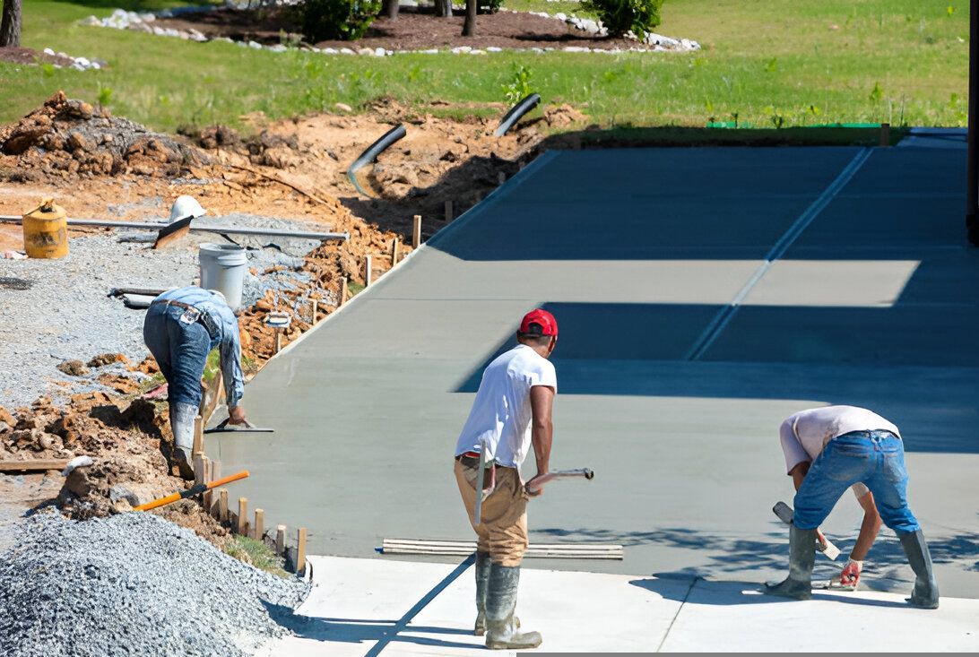Workers smoothing fresh concrete on a construction site.
