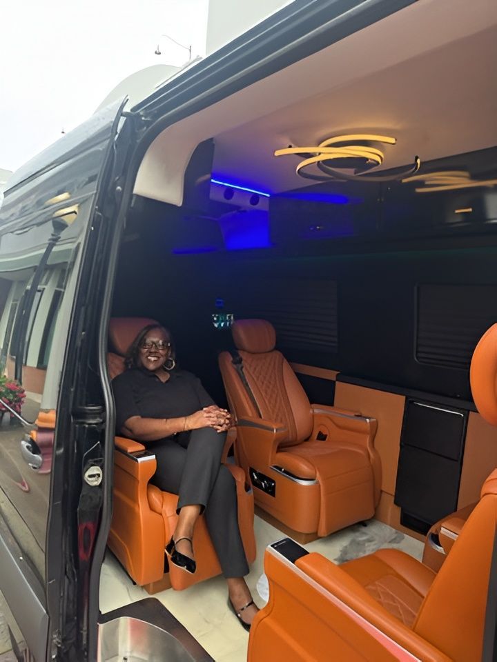 Man sitting in an orange leather van interior with blue accent lighting and a modern ceiling light
