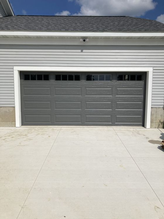 Gray two-car garage with driveway in front of a suburban home