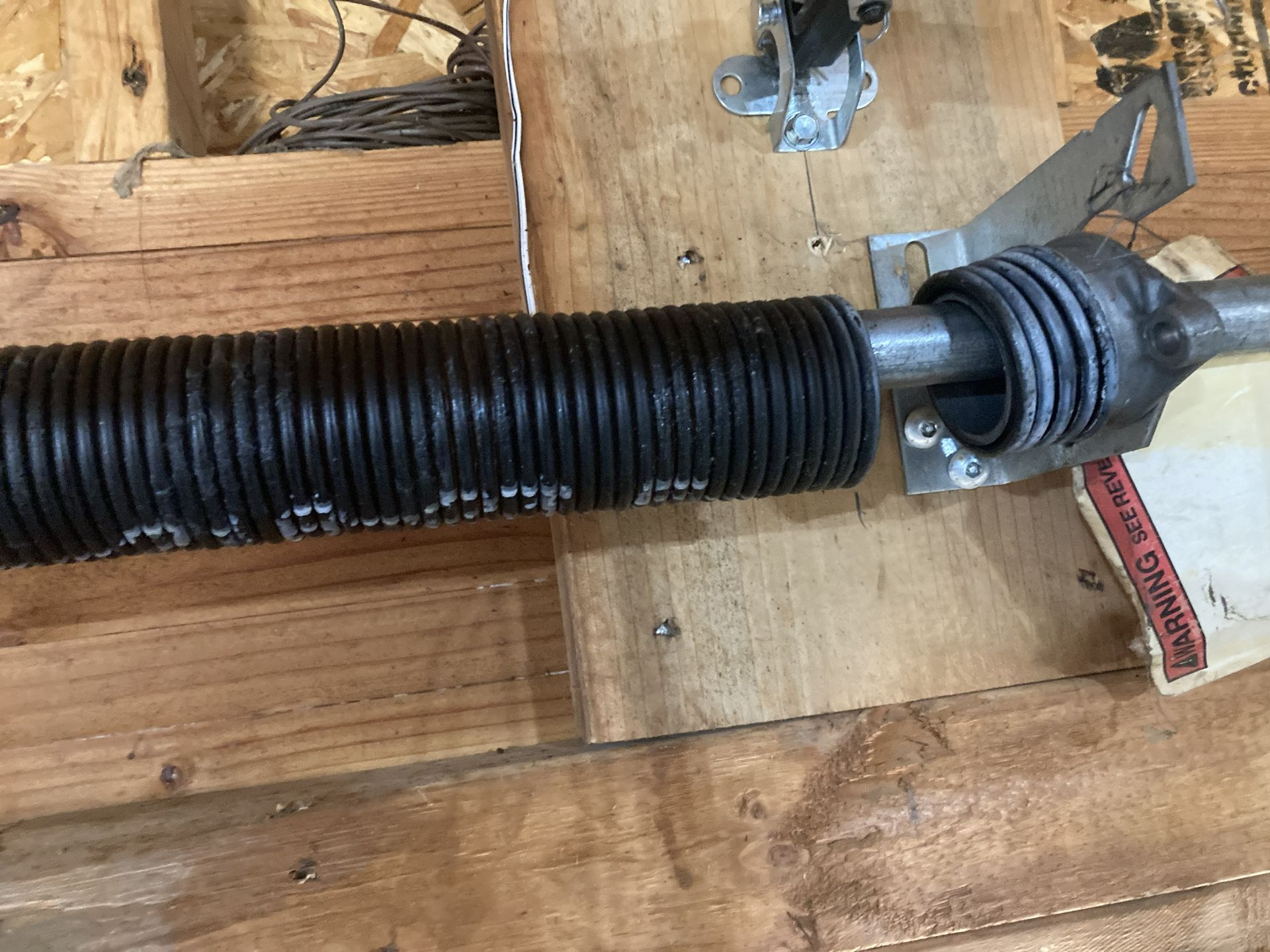 Car steering rack and rubber boot mounted on a wooden workbench.