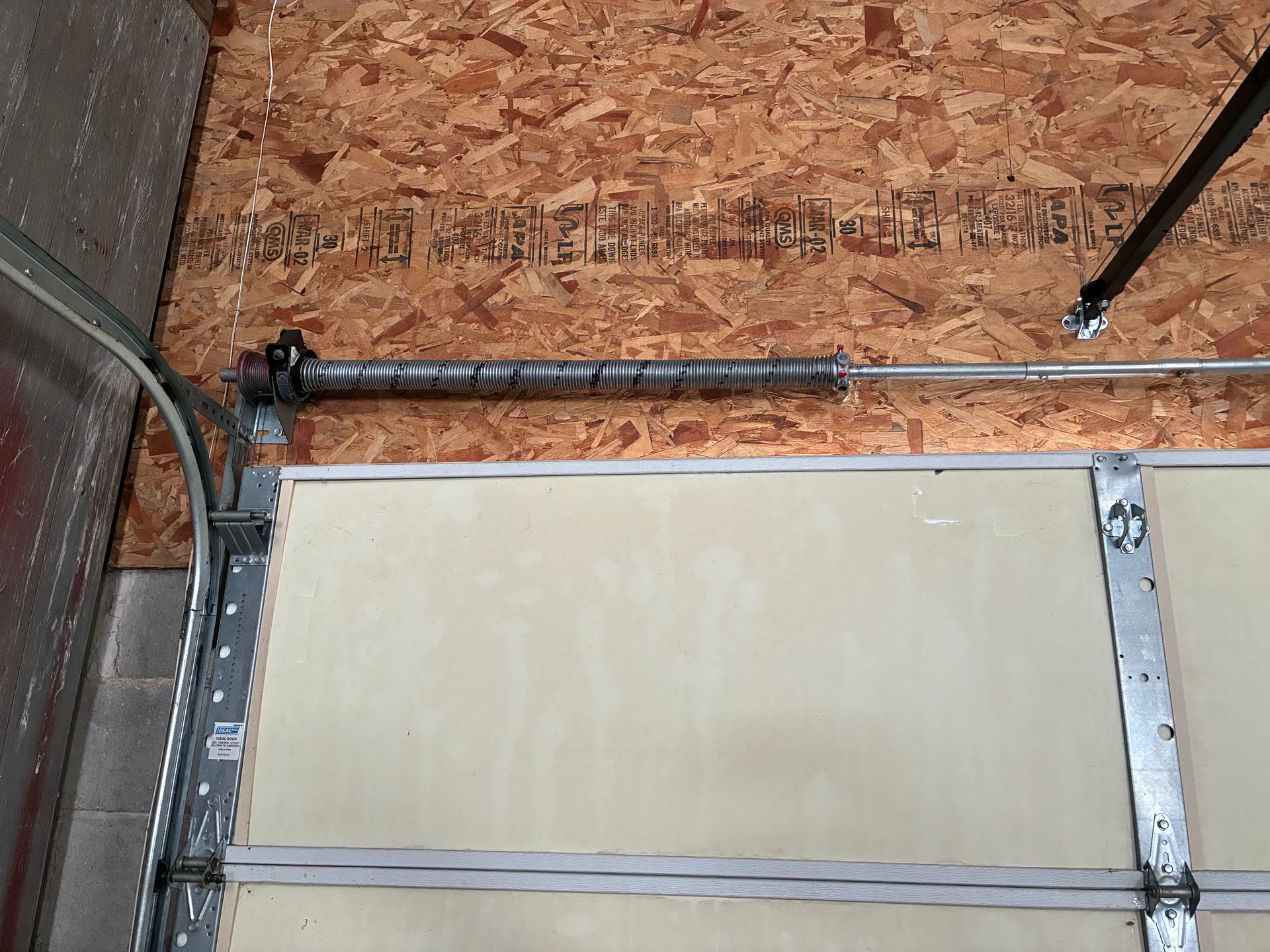 Metal cable conduit on an OSB floor above a framed white panel.