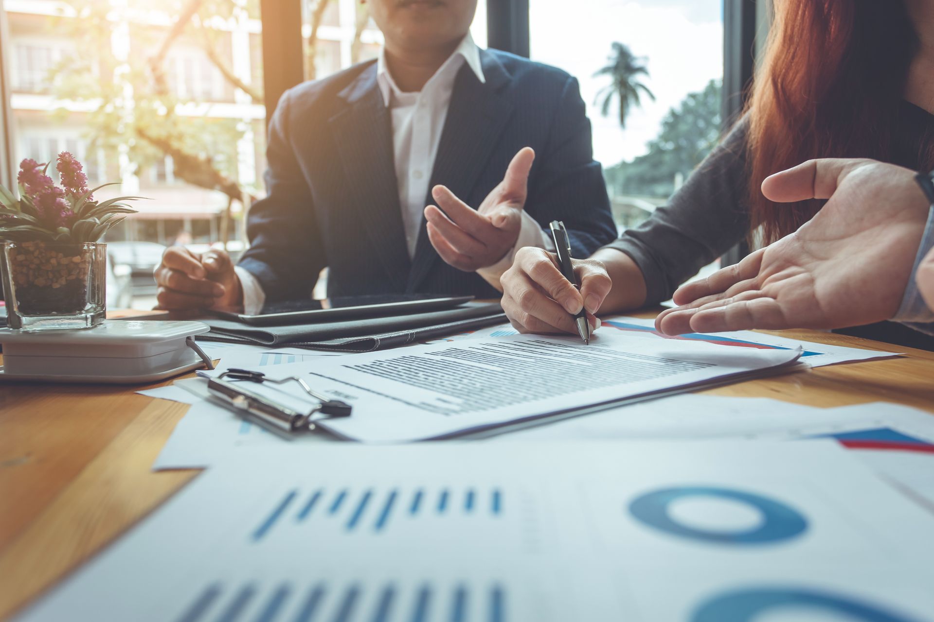People in a meeting reviewing charts and notes on a conference table