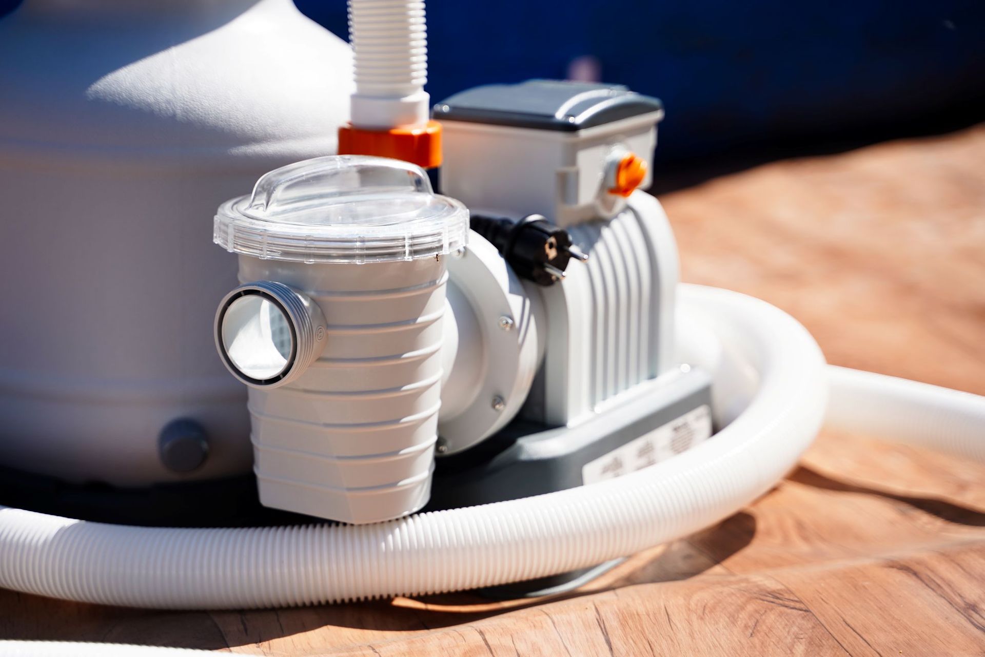 Pool filter pump with clear top and white hoses.
