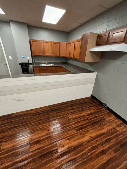 A kitchen with wooden cabinets , granite counter tops , and a sink.
