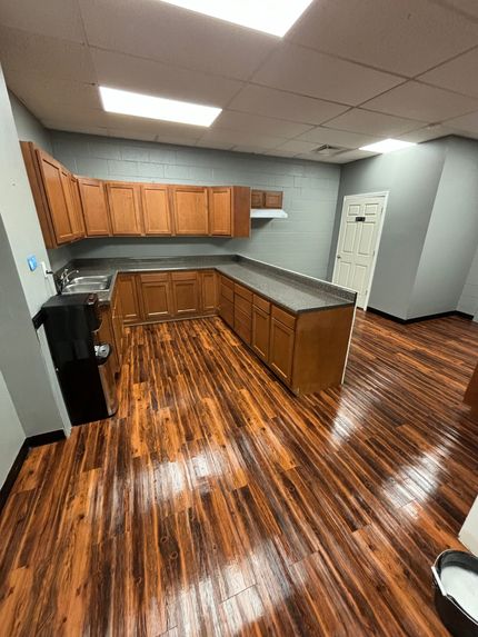 A kitchen with wooden cabinets , granite counter tops , and a sink.