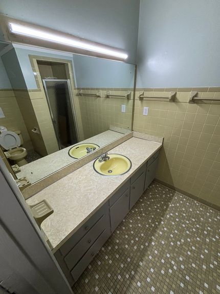 A bathroom with two sinks and a large mirror.