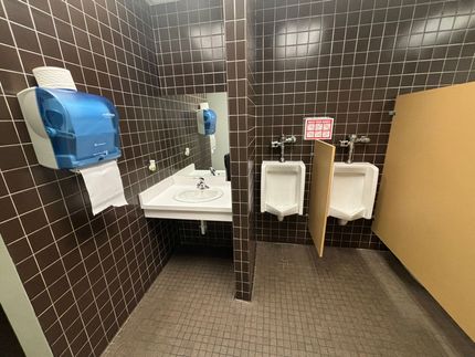 A public restroom with two urinals and a sink