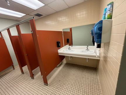 A public restroom with two sinks and a mirror.