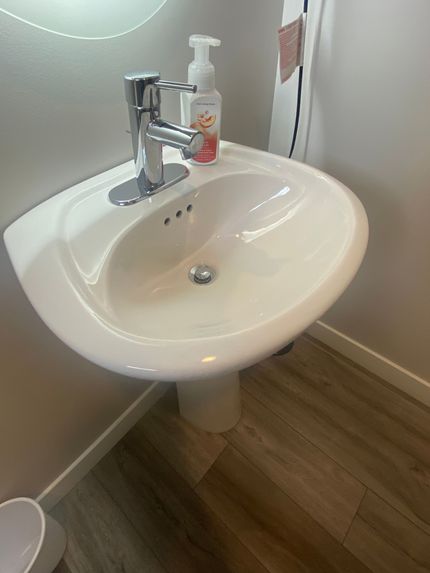 A bathroom sink with a soap dispenser on top of it.