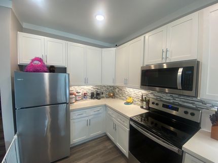 A kitchen with stainless steel appliances and white cabinets
