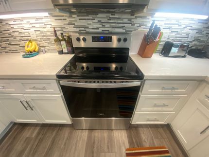 A kitchen with stainless steel appliances and white cabinets