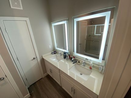 A bathroom with two sinks and two mirrors.