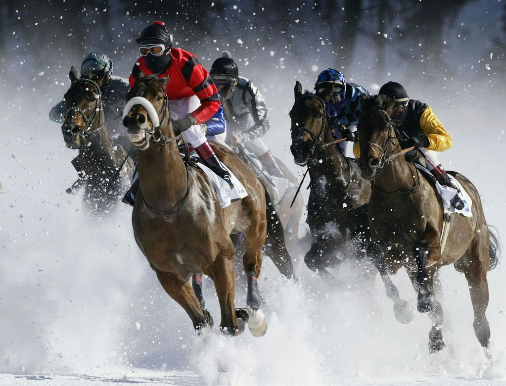 Horse race in heavy snow, jockeys riding fast through a snowy track with flying snow spray