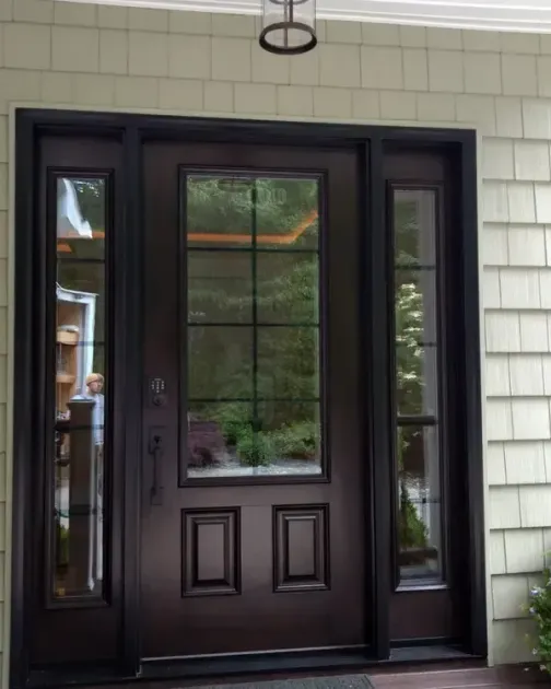 A dark-brown, six-paneled front door with a window divided into eight squares, framed by two vertical sidelight windows.