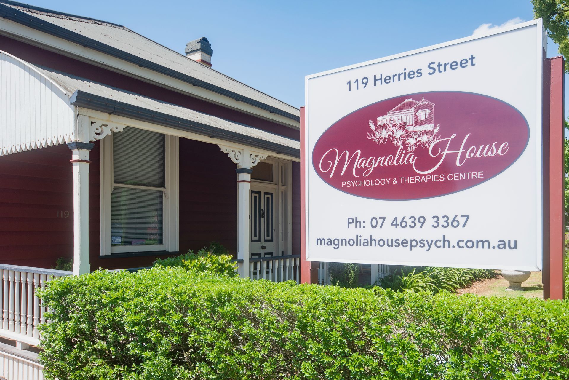 Magnolia House Psychology and Wellbeing Centre sign on a building with a porch.